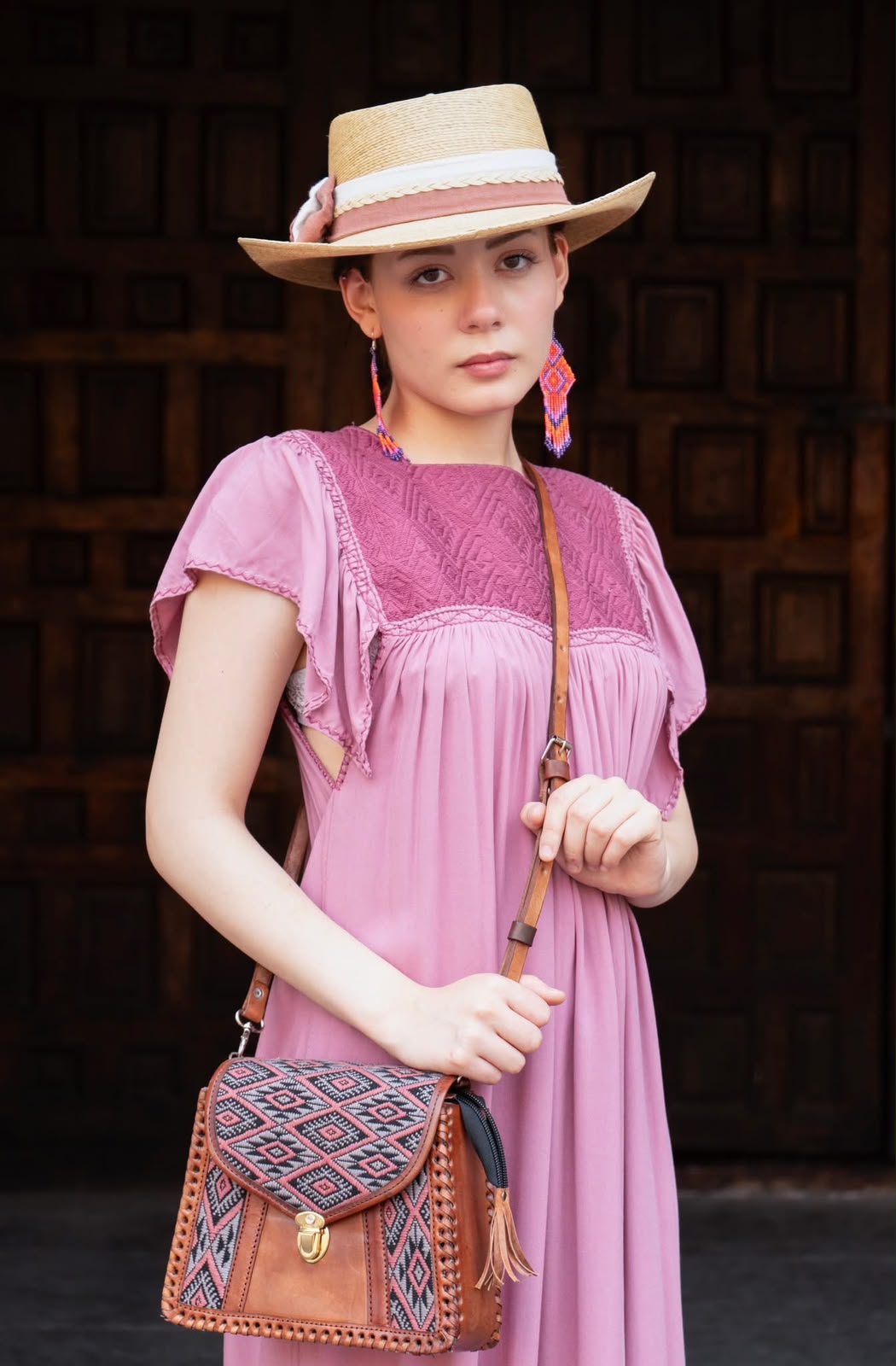 Vestido rosa, sombrero y bolso de cuero con tejido geométrico.